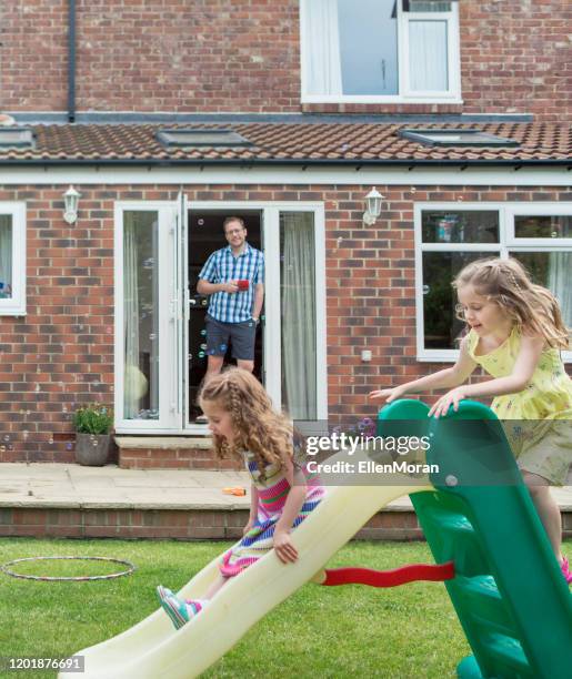 mother and daughter playing in garden - front garden uk stock pictures, royalty-free photos & images