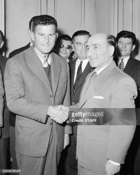 Photo prise le 06 janvier 1958 de René Billières , ministre de l'Education Nationale, serrant la main du rugbyman Jean Prat, après lui avoir remis...