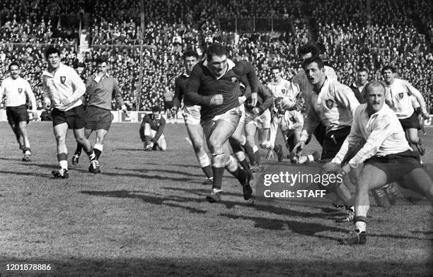 Le trois-quarts aile français Jean Dupuy s'apprête à passer le ballon à un coéquipier après avoir débordé la défense galloise, le 23 mars 1963 à...