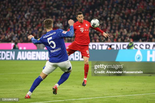 Robert Lewandowski of Bayern Muenchen scores the opening goal against Matija Nastasic of Schalke during the Bundesliga match between FC Bayern...