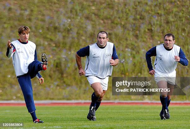 Le demi d'ouverture de l'équipe de France de rugby, François Gelez , botte le ballon, sous les yeux de ses coéquipiers, Jean-Jacques Crenca et...