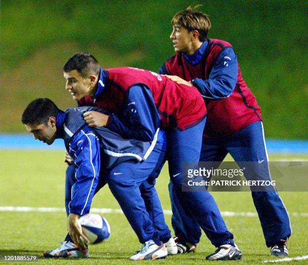 Les joueurs de l'équipe de France de rugby Dimitri Yachvili, Damien Traille et François Gelez se disputent le ballon, le 06 novembre 2002 au Centre...