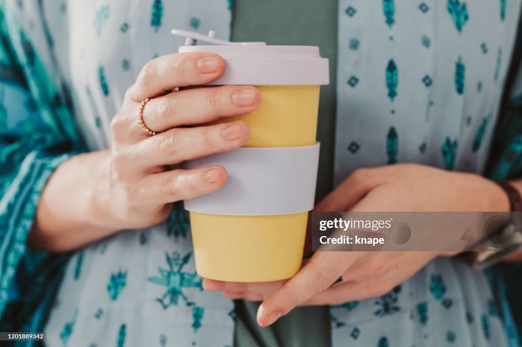 Mulher segurando para ir tirar copo de café