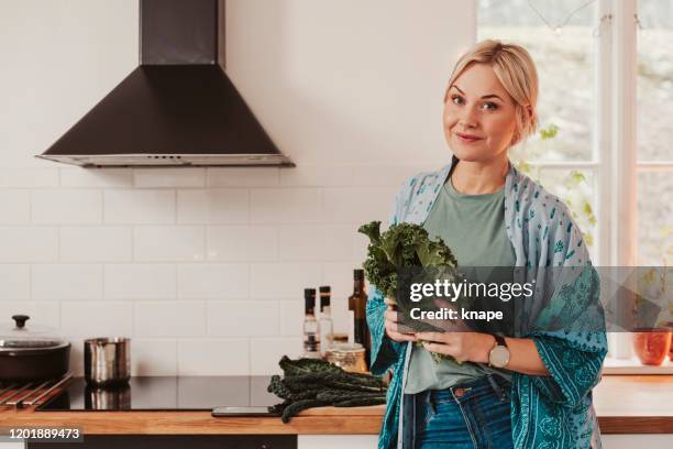 frau kochen lebensmittel in küche gemüse und grünkohl - grünkohl stock-fotos und bilder