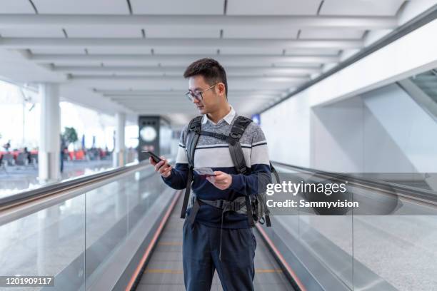 asian man waiting for the plane at the airport - boarding plane stock-fotos und bilder