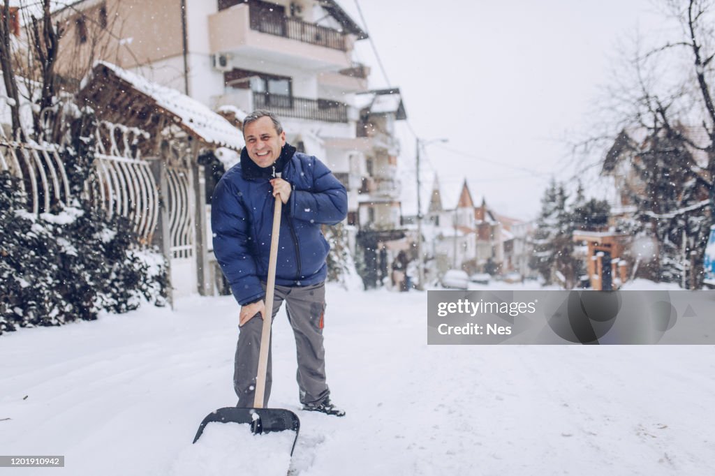 Man with snow shovel, winter weather