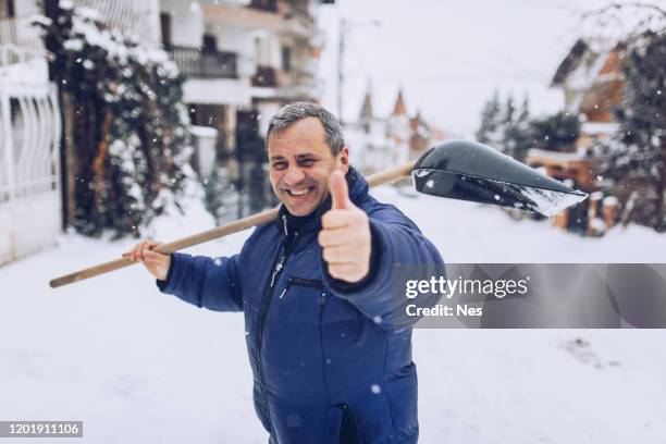 man with snow shovel, winter weather - snow shovel yard stock pictures, royalty-free photos & images