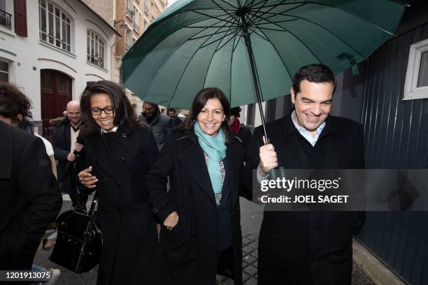 Paris' outgoing mayor and candidate to her succession Anne Hidalgo walks with Greek former Prime Minister Alexis Tsipras and one of her spokesperson...