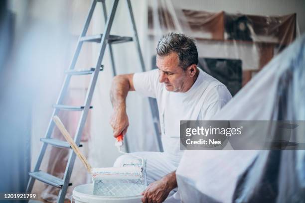il pittore prepara la vernice per la decorazione dell'appartamento - decorator foto e immagini stock