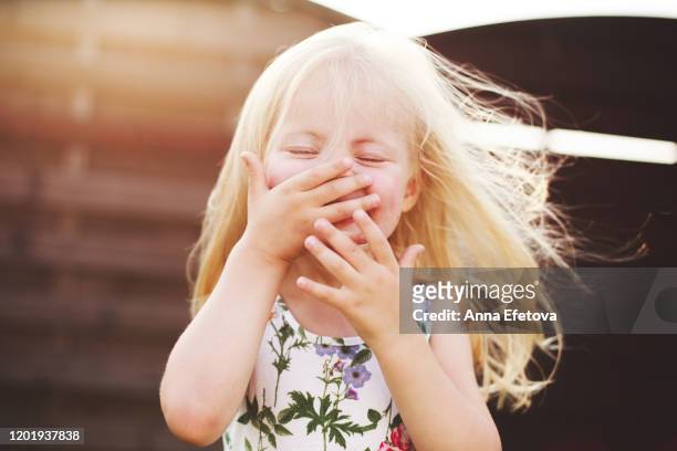 portrait of adorable little blonde girl who is laughing. - child laughing imagens e fotografias de stock