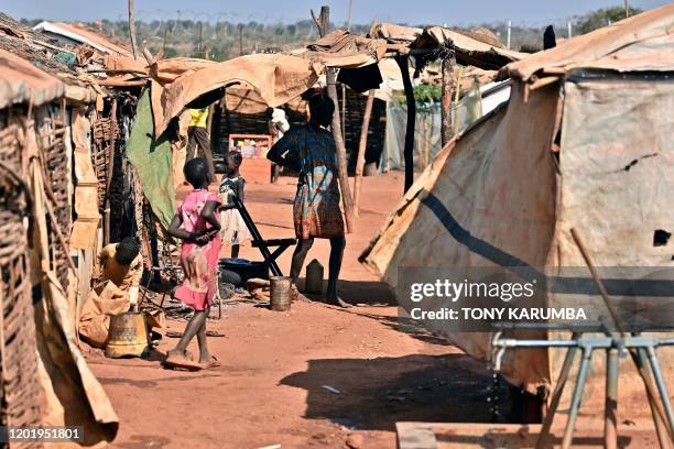 Young girls prepare for some chores outside their family's shelters at the Protection of Civilians site in Wau on February 1, 2020. - 13,000...
