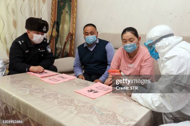 This photo taken on February 19, 2020 shows police officers visiting residents who live in remote areas in Altay, farwest China's Xinjiang region, to...