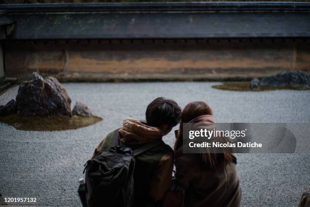 Couple sit to enjoy the rock garden in one of the famous landmark an empty Ryoan-ji temple in Japanese old capital city Kyoto. Following the outbreak...