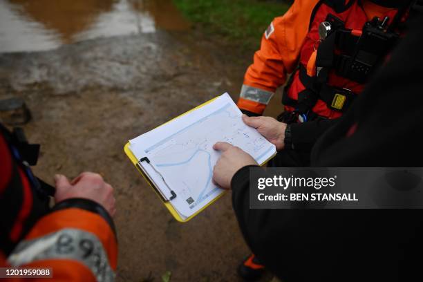 Hereford Fire and Rescue personnel look at a map of the area as they test flod water levels in the village of Hampton Bishop in Herefordshire,...