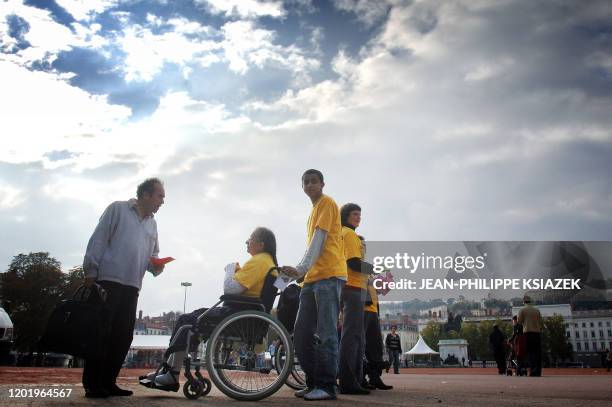 Une personne en fauteuil roulant distribue des tracts, le 10 octobre 2007 à Lyon, alors que l'APF organise jusqu'au 14 octobre dans toute la France...