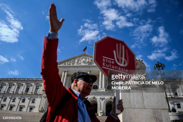 Man holds a stop sign reading "Stop Euthanasia" during a protest against the decriminalization of euthanasia in front of the parliament on February...