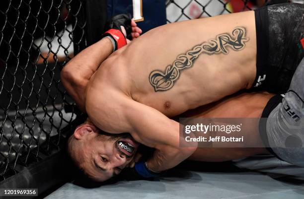 Alex Perez secures an arm triangle choke against Jordan Espinosa in their flyweight fight during the UFC Fight Night event at PNC Arena on January...