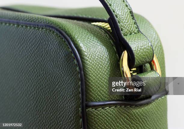 strap details on a green handbag against white background - metallic purse stock-fotos und bilder