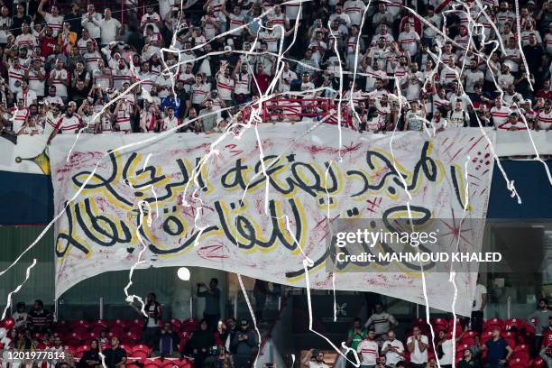 Zamalek football fans wave a giant banner reading in Arabic "glory is made by men, may you be continental champions", as they cheer for their team...
