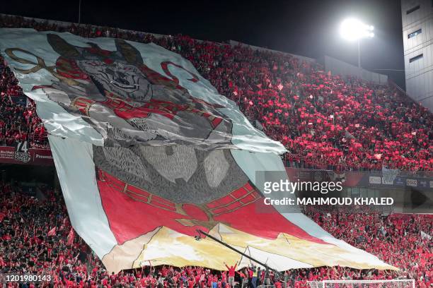 Ahly SC's fans wave a giant banner showing a depiction of the ancient Egyptian god Anubis dressed in red costume, during the Egyptian Super Cup final...