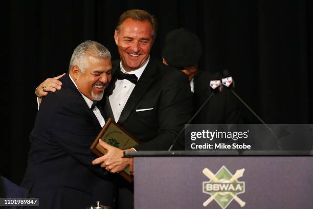 Luis Sojo and Al Leiter hug after receiving the "Willie, Mickey and the Duke" Award during the 97th annual New York Baseball Writers' Dinner on...