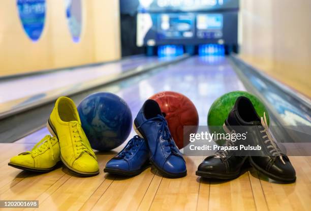 bowling equipment. close up of bowling shoes and lilac ball lying on bowling alley - bowling shoe stock pictures, royalty-free photos & images