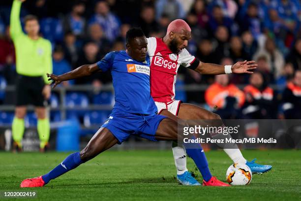 Dakonam Djene of Getafe FC competes for the ball with Ryan Babel of AFC Ajax during the UEFA Europa League round of 32 first leg match between Getafe...