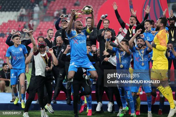 Zamalek SC's captain Mahmoud Abdel Razek 'Shikabala' jumps with the Egyptian Super Cup trophy as his other teammates celebrate after winning the...