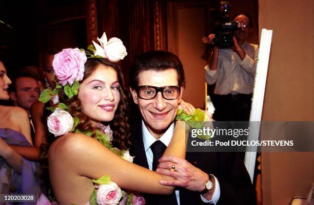 Franch model Laetitia Casta, with flowers in her hair, hugs French fashion designer Yves Saint Laurent at Yves Saint Laurent Fashion Show 2000 on...