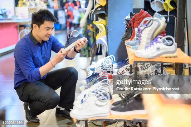 asian office worker man choosing shoe while doing shopping at the shopping mall after office work time, city life male shopping, sale, shopping, fashion, style and people concept - choosing shoes stock pictures, royalty-free photos & images