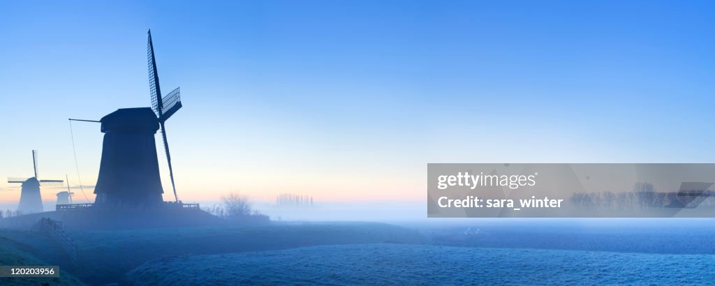 Traditional Dutch windmills in winter at sunrise