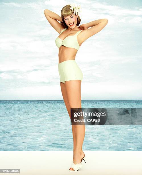 vintage pin-up girl wearing bathing suit at the ocean - glamour model stock pictures, royalty-free photos & images