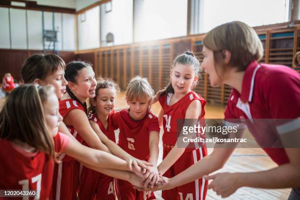 female  school basketball team playing game - basketball team work stock pictures, royalty-free photos & images