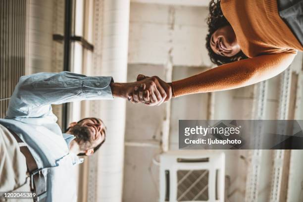 zwei menschen schütteln hände - handshake stock-fotos und bilder
