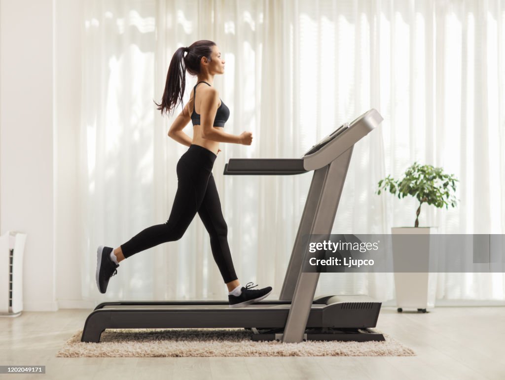 Young woman running on a treadmill indoors