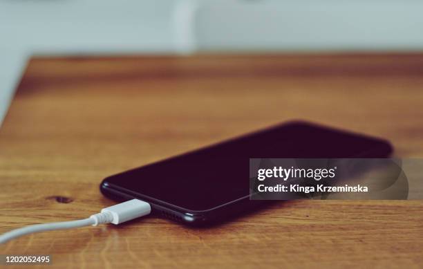 mobile phone charging - phone on table stock pictures, royalty-free photos & images