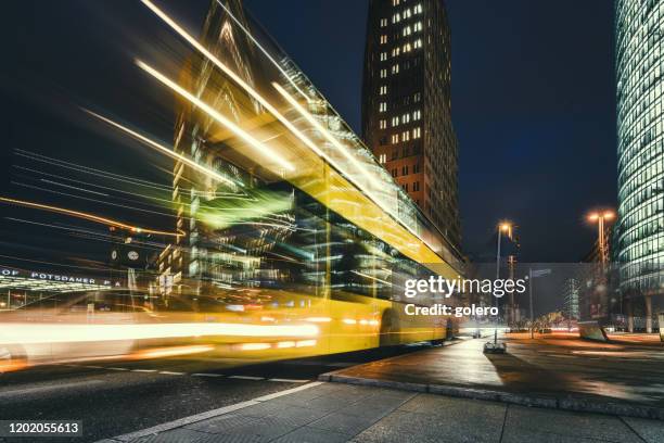 gelber bus am potsdamer platz zur blauen stunde - strassen nacht stadt stock-fotos und bilder