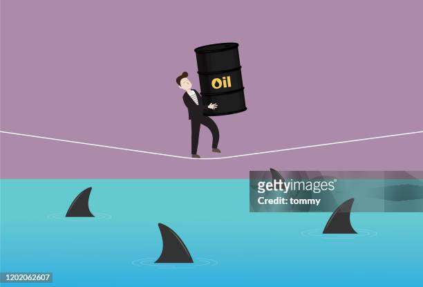 businessman holds a crude oil and walking on a rope with a shark in the sea - storage tank stock illustrations