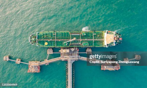 aerial top view oil ship tanker load or unload oil at loading dock from refinery for transportation on the sea. - marine marchande photos et images de collection