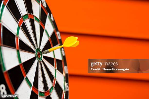 dart arrow hitting in the target center of dartboard - arrows target fotografías e imágenes de stock