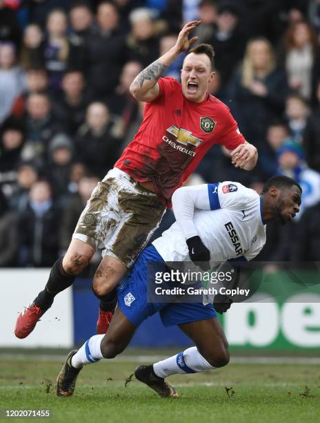 Phil Jones of Manchester United is tackled by Corey Blackett-Taylor of Tranmere Rovers during the FA Cup Fourth Round match between Tranmere Rovers...