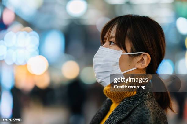 porträt einer jungen frau, die gesichtsmaske trägt - severe acute respiratory syndrome stock-fotos und bilder