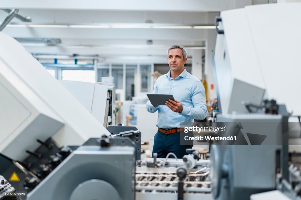 Businessman using a tablet in a factory