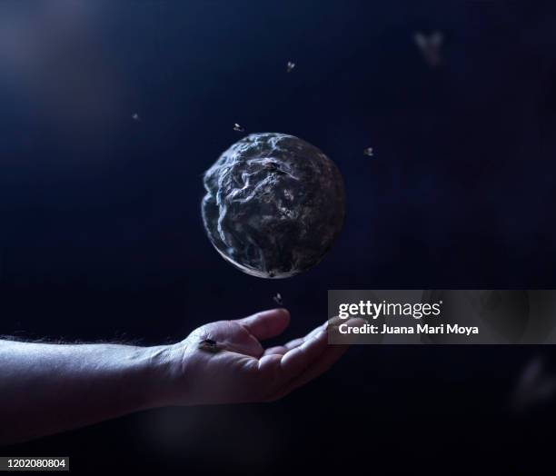 conceptual photograph of man's hand, which dominates and rots the planet earth - v rest of the world stock-fotos und bilder