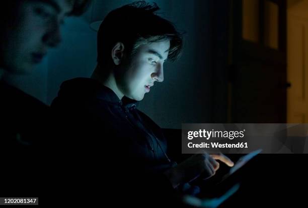 two teenage boys using technology at home in the dark - teenager awe stock pictures, royalty-free photos & images