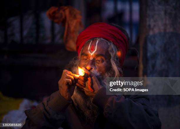 Sadhu smokes marijuana using a chillum a traditional clay pipe as a holy offering on the eve of Maha Shivaratri. Maha Shivaratri, 'the Great Night of...