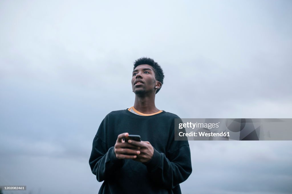 Teenager using his smartphone, low angle view