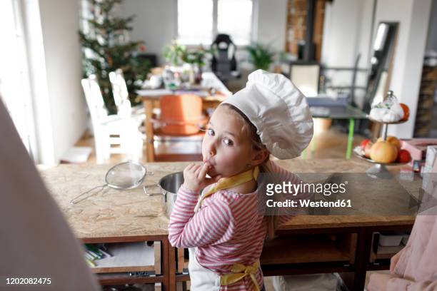 girl wearing chef's hat in the kitchen - kids cooking stock-fotos und bilder