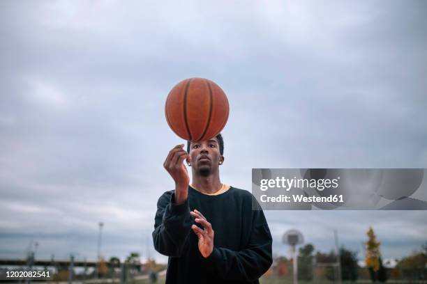 teenager balancing basketball on his finger - streetball stock pictures, royalty-free photos & images