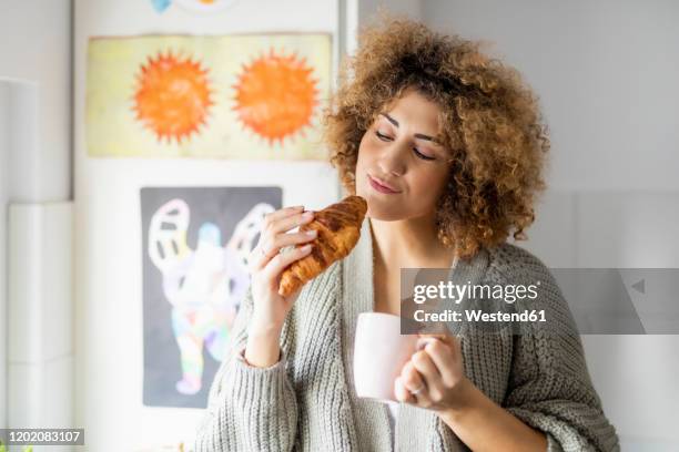 woman eating croissant and drinking coffee at home - eating croissant stock pictures, royalty-free photos & images